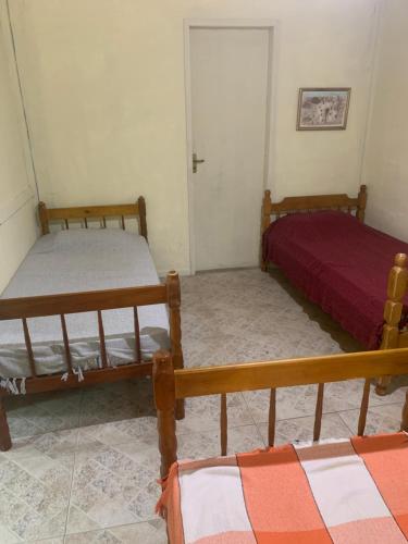 a bedroom with two beds and a red bed at Aldeia Gaia Chalés in Teresópolis