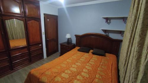 1 dormitorio con 1 cama con colcha de color naranja en Casa Cuenca en Cuenca