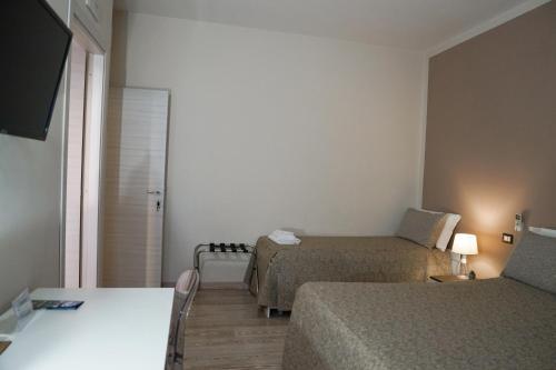 a small room with two beds and a television at SalernoPrestige rooms in Salerno