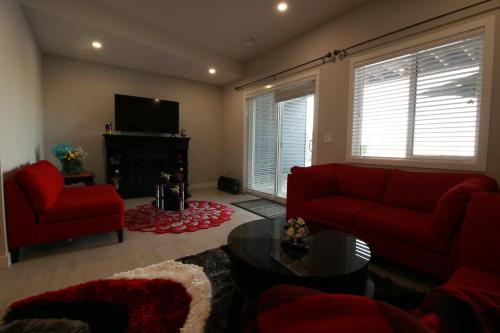 a living room with a red couch and a fireplace at Feel at home in Chestermere in Chestermere