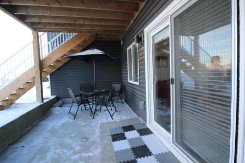 a patio with a table and chairs on a porch at Feel at home in Chestermere in Chestermere