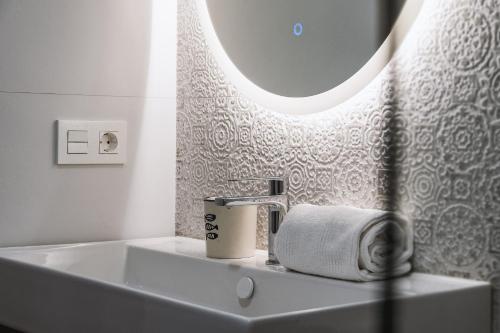 a white bathroom with a sink and a mirror at Essential by Charlie in Jávea