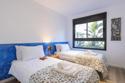 two beds in a room with a window at Essential by Charlie in Jávea