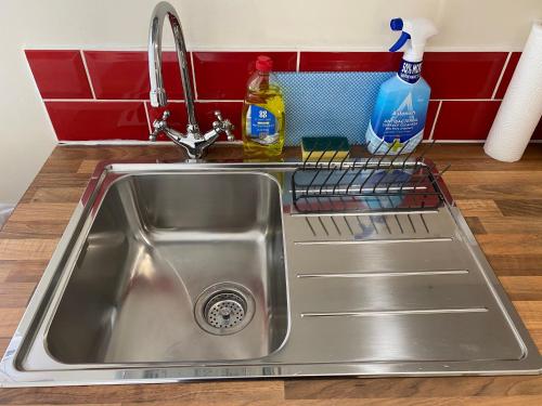 a kitchen sink with a dish rack next to it at Self-Contained Double-bed Studio in Central Sherwood in Nottingham