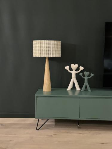 deux personnages de jouets sur une commode à côté d'une lampe dans l'établissement Green h(e)aven, à Nieuport