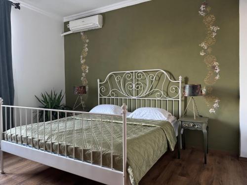 ein Schlafzimmer mit einem Bett und einer grünen Wand in der Unterkunft Vila Speranta in Pleşcoi