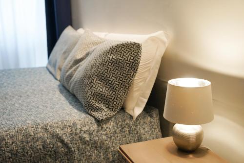 a bed with a pillow and a lamp on a table at SalernoPrestige rooms in Salerno