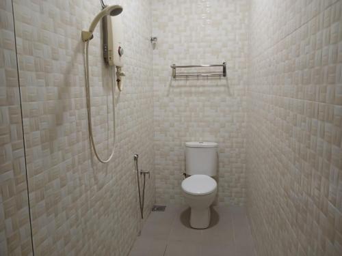 a bathroom with a toilet and a shower at Weng Kong Homestay in Slim River