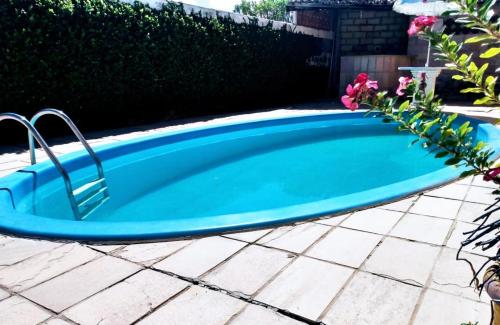 a pool in a yard with a blue swimming pool at Casa com 4 quartos em condomínio fechado in Tamandaré