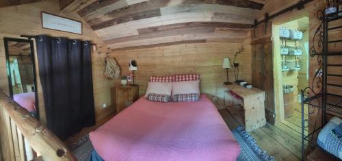a large bed in a small room in a tiny house at Le mazot d'H in Entremont