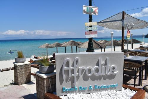 a sign for a beach bar and restaurant on the beach at Afrodite Seaside Rooms in Kallithea Halkidikis