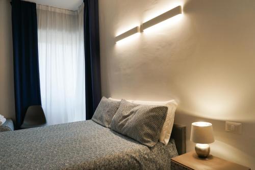 a bedroom with a bed with a lamp and a window at SalernoPrestige rooms in Salerno