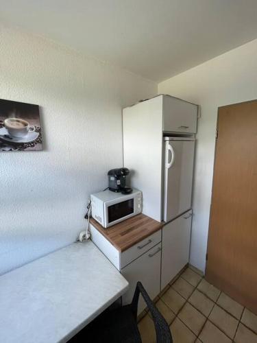 a small kitchen with a refrigerator and a microwave at Wohnung nähe Düren Zentrum in Düren - Eifel