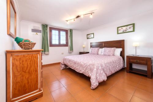 Schlafzimmer mit einem Bett, einer Kommode und einem Fenster in der Unterkunft Casa Diama in Yaiza