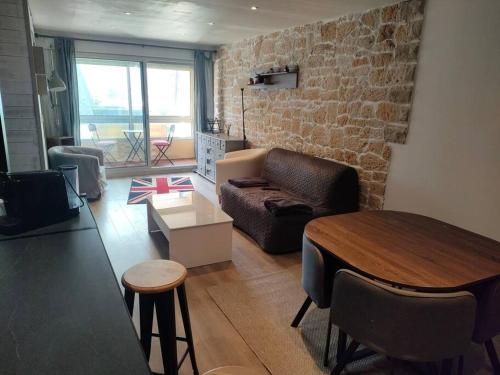 sala de estar con sofá y mesa en bienvenue chez vous, en Bernières-sur-Mer