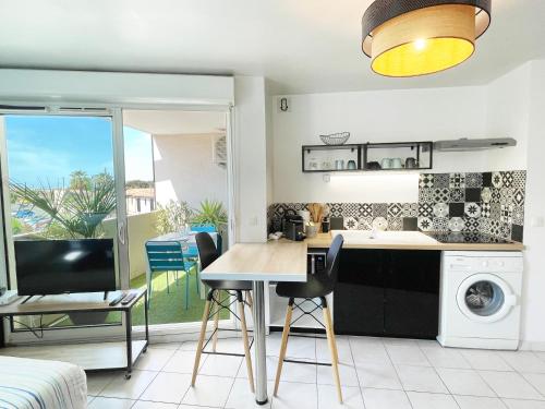 une cuisine et un salon avec une table et des chaises dans l'établissement Lapin Blanc - Joli studio avec terrasse, à Marseille