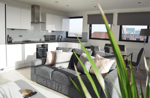 uma sala de estar com um sofá e uma cozinha em Morland House em Romford