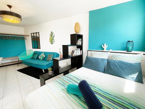 une chambre avec un lit et un mur bleu dans l'établissement Lapin Blanc - Joli studio avec terrasse, à Marseille