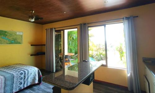 Zimmer mit einem Bett und einer Glastheke mit einem Fenster in der Unterkunft Arenal Villas Tranquilas, free-standing equipped houses in Nuevo Arenal