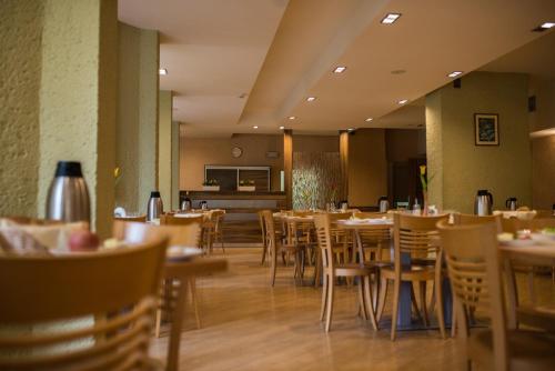 een eetkamer met tafels en stoelen in een restaurant bij Ośrodek Uzdrowiskowy Malwa in Ustroń