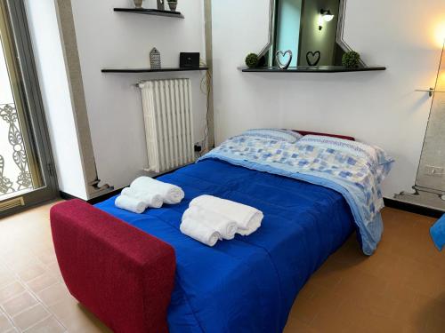 a bedroom with two towels on a blue bed at Nel Pieno Centro Storico [Tutto a Due Passi] in Casale Monferrato