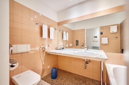 a bathroom with a toilet and a sink at Hotel Kunsthof in Vienna