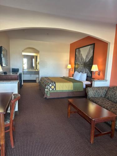a hotel room with a bed and a couch at Belleza Inn & Suites Humble / FM 1960 in Humble