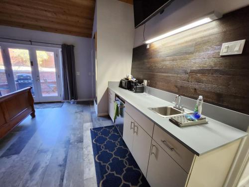 a kitchen with a sink and a wooden wall at Guest Suite Torrey Pines Golf, Salk, Scripp, Ucsd in San Diego