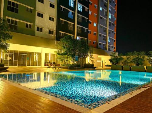 una piscina frente a un edificio por la noche en AF Homestay 3BR Near KLIA Free Wifi Netflix, en Sepang