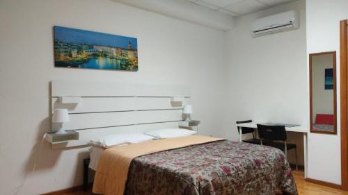 1 dormitorio con 1 cama y una pintura en la pared en Bunker degli inventori, en Foggia