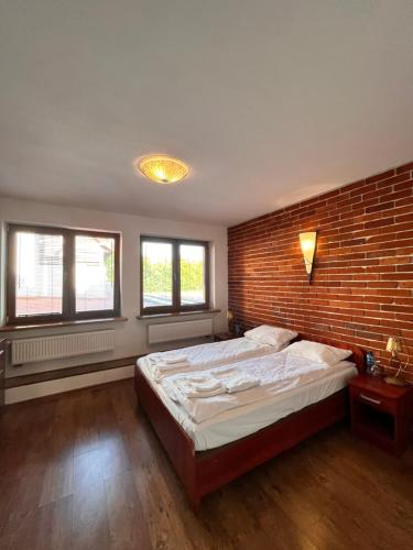 - une chambre avec un grand lit et un mur en briques dans l'établissement Dwór Sulejów, 