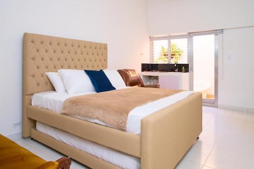 a bedroom with a large bed with a large window at Hotel Boutique Fiorentina Medellín in Medellín
