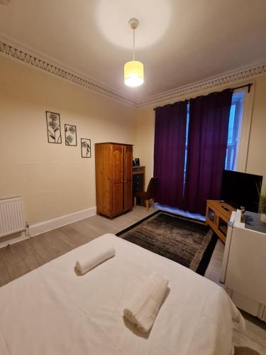 a bedroom with a bed with two towels on it at Cathcart Place Rooms in Edinburgh