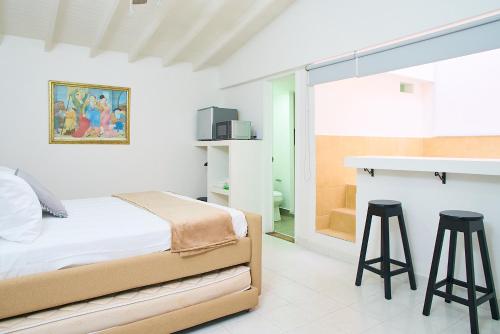 a bedroom with a bed and two bar stools at Hotel Boutique Fiorentina Medellín in Medellín
