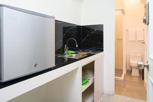 a small kitchen with a sink and a toilet at Apartahotel Fiorentina Boutique in Medellín