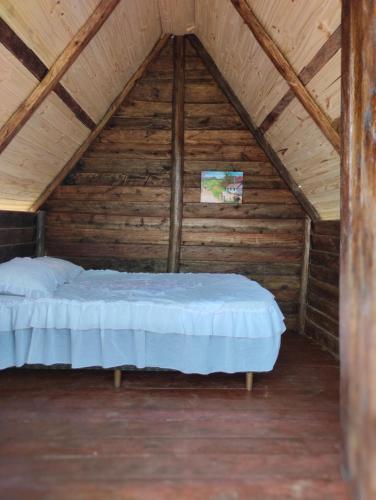 a bedroom with a bed in a wooden attic at Pousada 4 estações/chalés in Sapopema