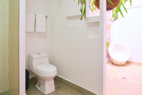 a white bathroom with a toilet and a sink at Hotel Boutique Fiorentina Medellín in Medellín