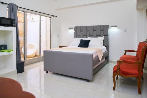 a bedroom with a large bed and a chair at Hotel Boutique Fiorentina Medellín in Medellín