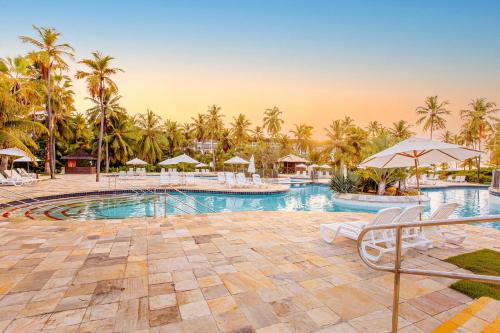 una piscina en un complejo con palmeras en Sauipe Resorts Ala Terra - All Inclusive, en Costa do Sauipe