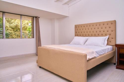 a bedroom with a large bed with a large window at Hotel Boutique Fiorentina Medellín in Medellín