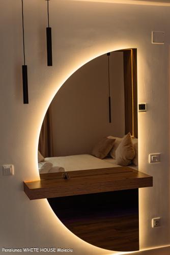 a bedroom with a bed in a round mirror at White House Moieciu in Moieciu de Jos
