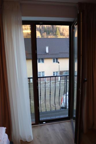 a sliding glass door with a view of a house at White House Moieciu in Moieciu de Jos