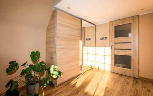 a room with a wooden door and a plant at Old Town Studio with Mezzanine in Gdańsk