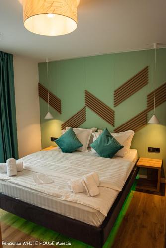 a bedroom with a large bed with green walls at White House Moieciu in Moieciu de Jos