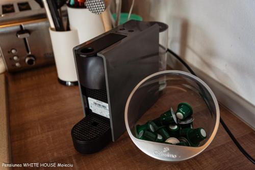 a black appliance with a bowl of green glass bottles at White House Moieciu in Moieciu de Jos