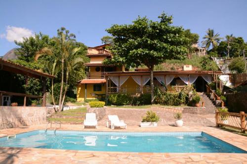 a swimming pool in front of a house at VELINN Pousada Aporan Ilhabela in Ilhabela