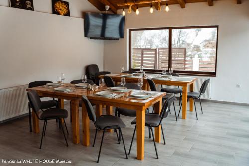 a dining room with wooden tables and chairs at White House Moieciu in Moieciu de Jos