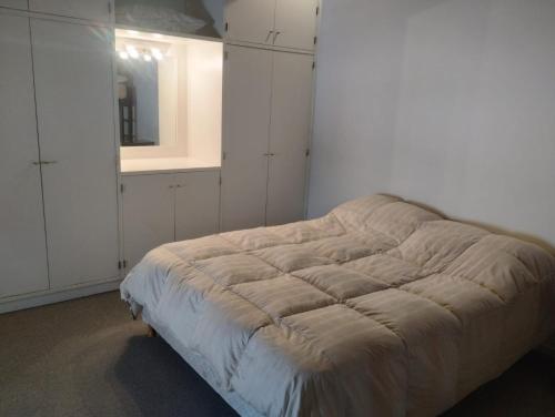 1 dormitorio con 1 cama con espejo y armarios blancos en Altos Penitentes Lomas Blancas, dúplex en Uspallata