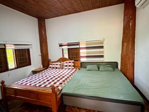 sypialnia z łóżkiem w pokoju z oknami w obiekcie Bansuan Resort, Long, Phrae w mieście Long