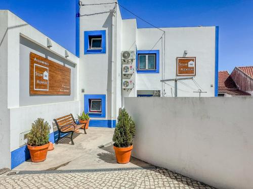 un edificio con pareti bianche e blu e piante in vaso di Solar do Alentejo a Cercal